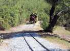 Train approaching the last curve that appears to have been freshly replaced and ballasted